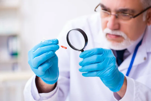 Viejo criminólogo experto trabajando en el laboratorio como evidencia — Foto de Stock