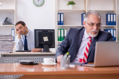Eski patron ve genç erkek çalışan ofiste.