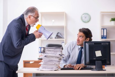 Eski patron ve genç erkek çalışan ofiste.