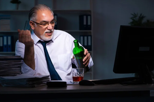 Velho empregado do sexo masculino trabalhando até tarde no escritório — Fotografia de Stock