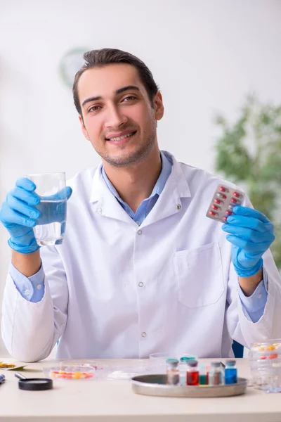 Joven asistente de laboratorio masculino en concepto de síntesis de fármacos — Foto de Stock