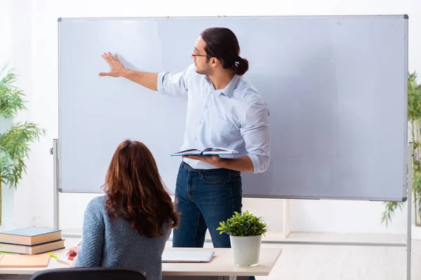 Junge Studentin und männlicher Lehrer im Klassenzimmer — Stockfoto