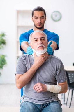 İlk yardım konseptinde genç erkek doktor ve yaşlı hasta.