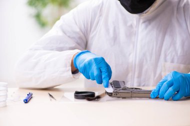 Erkek kriminolog kanıt için laboratuarda çalışıyor.