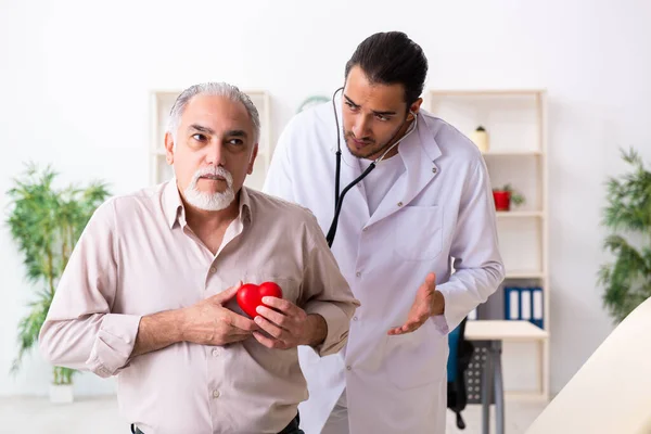 Yaşlı adam genç doktor kardiyoloğu ziyaret ediyor. — Stok fotoğraf