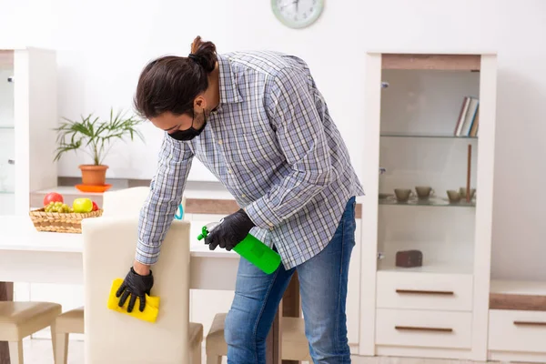 Fiatal férfi vállalkozó takarítás a ház koronavírus koncepció — Stock Fotó