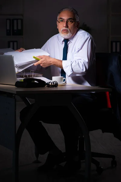Viejo empleado trabajando hasta tarde en el lugar de trabajo — Foto de Stock