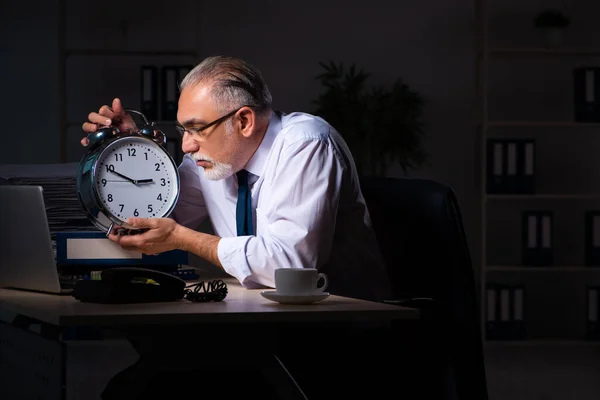Velho empregado do sexo masculino que trabalha até tarde no local de trabalho — Fotografia de Stock