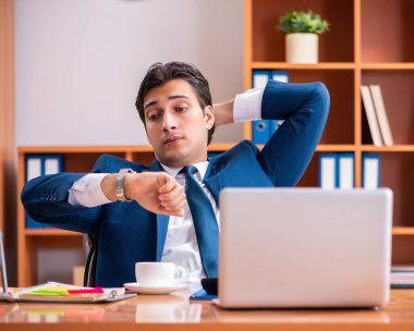 Genç yakışıklı işadamı ofiste çalışıyor.