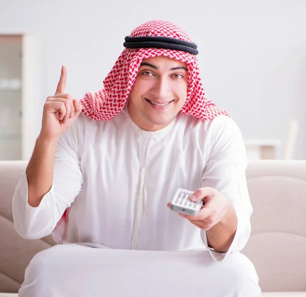 Arab fiatalember ült a kanapén tévénézés — Stock Fotó