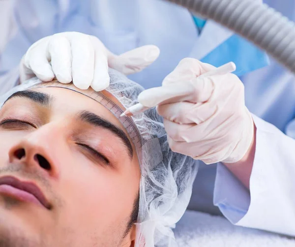 Médico que mede o rosto dos pacientes antes da cirurgia plástica — Fotografia de Stock