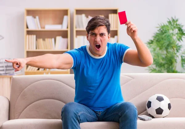 Hombre viendo fútbol en casa sentado en el sofá — Foto de Stock