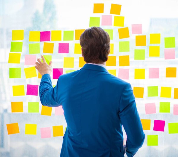 Young handsome employee with many conflicting priorities