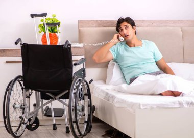 Genç yakışıklı engelli adam evde iyileşiyor.