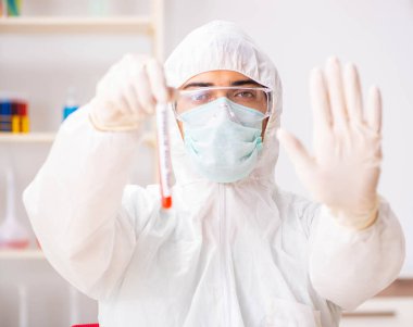 Genç yakışıklı laboratuvar asistanı hastanede kan örnekleri test ediyor.