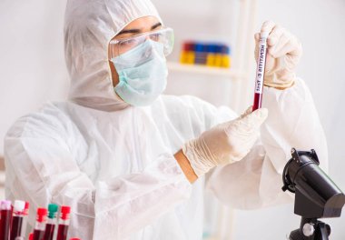 Genç yakışıklı laboratuvar asistanı hastanede kan örnekleri test ediyor.