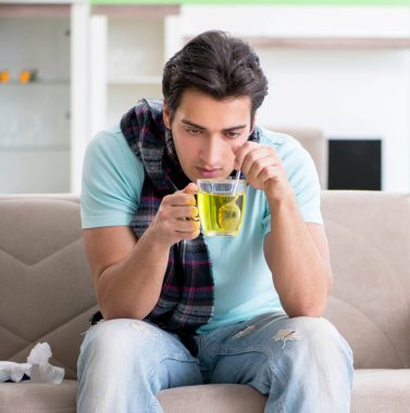 Evde hastalıktan muzdarip genç yakışıklı bir adam.