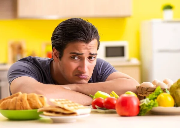 Man having hard choice between healthy and unhealthy food — Stock Photo, Image