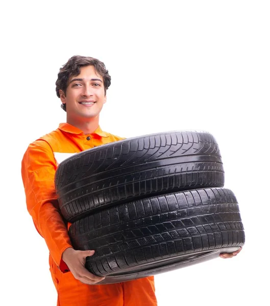 Молодий працівник гаража з шиною ізольовано на білому — стокове фото