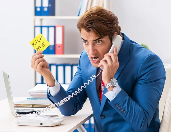 Office prank with kick me message on sticky note