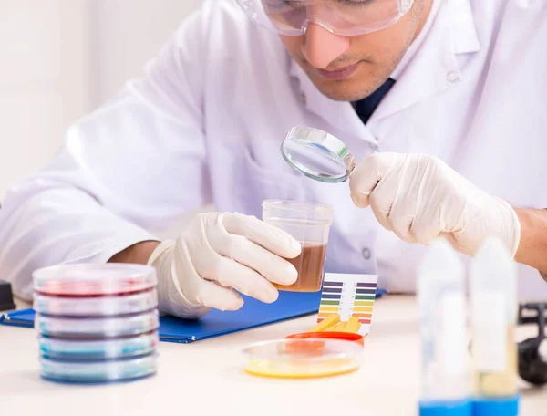 Chimiste en laboratoire vérifiant avec des bandelettes ph — Photo