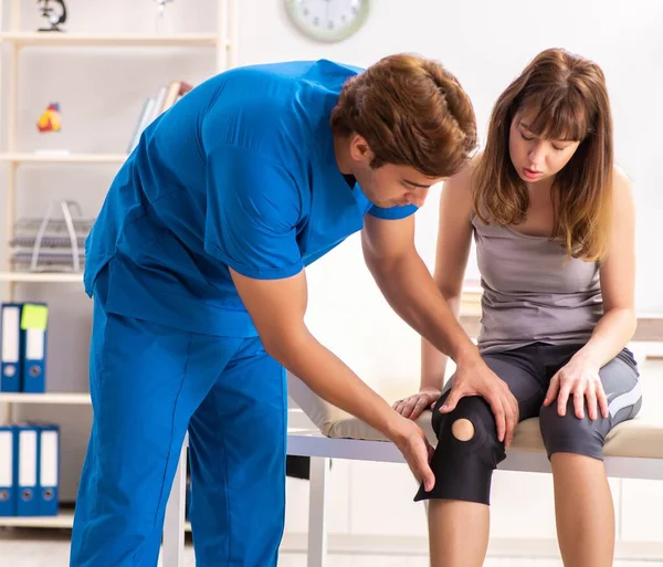 Jeune patiente visitant un médecin traumatologue masculin — Photo