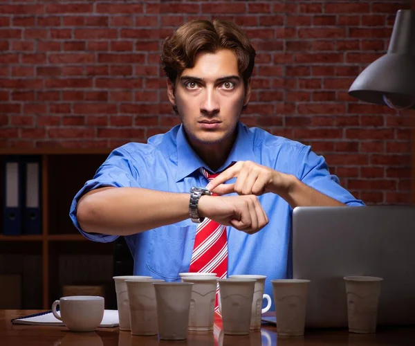 Young employee drinking coffee working at night shift — Stock Photo, Image