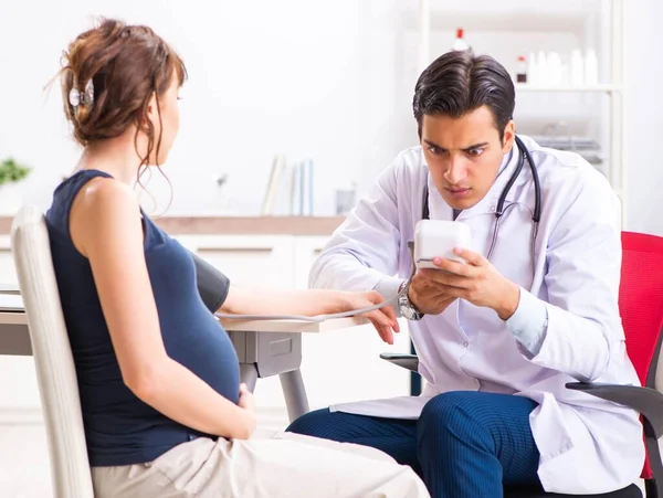 Jeune médecin vérifiant la pression artérielle des femmes enceintes — Photo