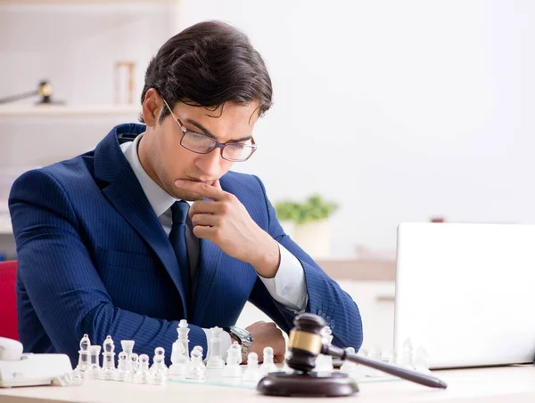 Jeune avocat jouant aux échecs pour former sa stratégie judiciaire et ses tactus — Photo
