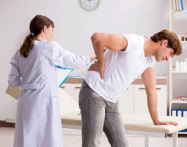 Male patient visiting young female doctor chiropractor — Stock Photo, Image