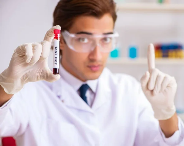 Asistente de laboratorio joven guapo analizando muestras de sangre en el hospital — Foto de Stock