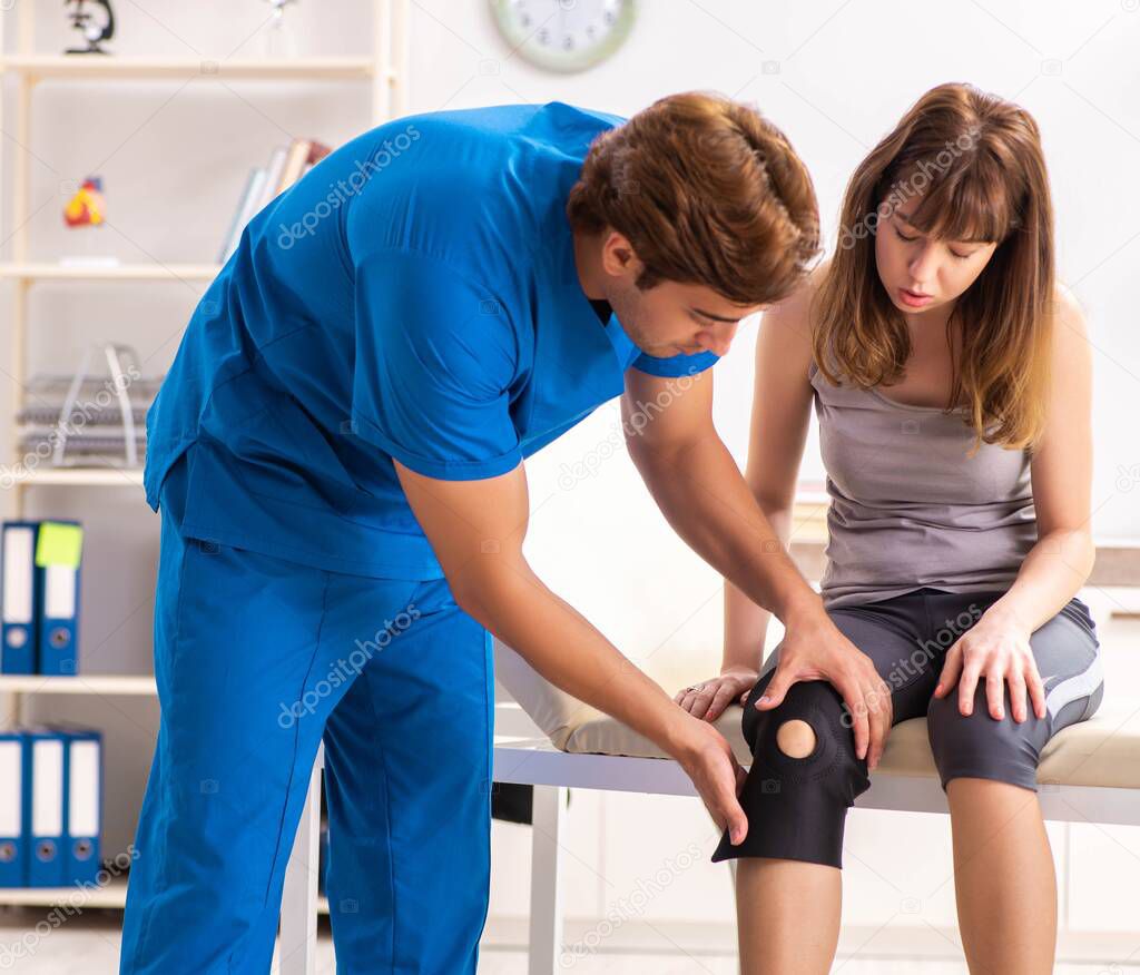 Young female patient visiting male doctor traumatologist