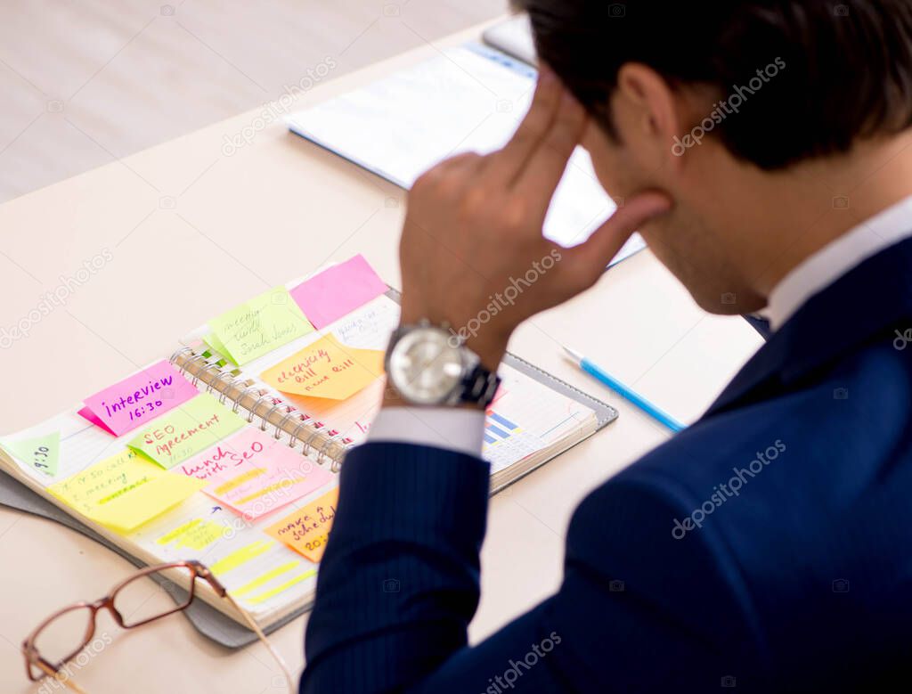 Young handsome employee planning his work activity