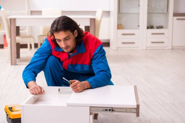 Genç erkek marangoz içeride çalışıyor.