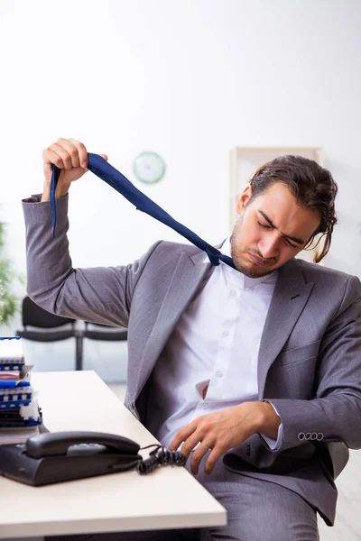 Giovane dipendente maschio infelice con il lavoro eccessivo — Foto Stock