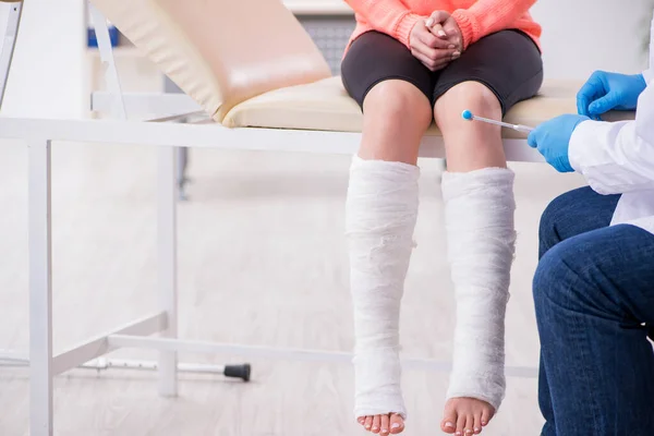 Joven pierna lesionada mujer visitando viejo médico traumatólogo — Foto de Stock