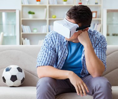 Sanal gerçeklik gözlüğü takan bir adam futbol maçı izliyor.