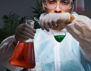 Gece geç saatlere kadar çalışan genç erkek kimyager.