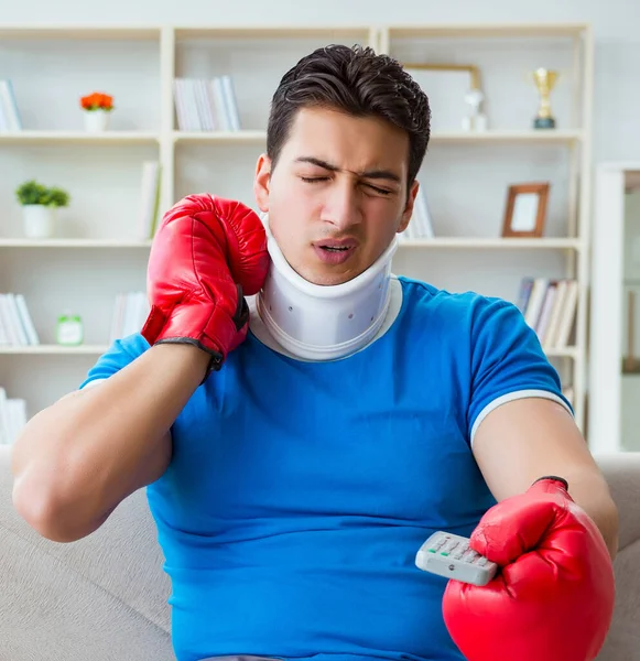 Egy férfi nyaksérüléssel otthon nézi a bokszot. — Stock Fotó
