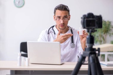 Genç erkek doktor blogu için video kaydediyor.