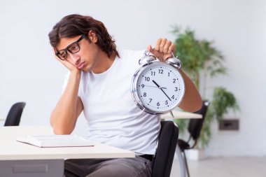 Sınıfta oturan genç erkek öğrenci.