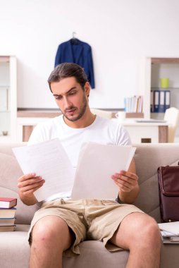 Evde sınava hazırlanan genç bir erkek öğrenci.