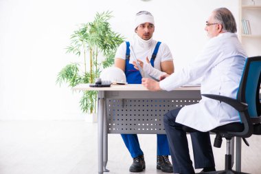 Genç erkek müteahhit yaşlı doktoru ziyaret ediyor.