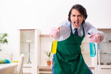Genç işadamı evi temizliyor.