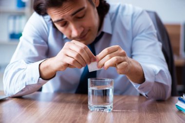 Hasta erkek çalışan ofiste acı çekiyor.