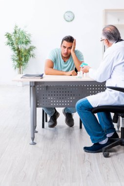 Genç adam ziyaret eski erkek doktor