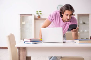 Evde sınava hazırlanan genç bir erkek öğrenci.