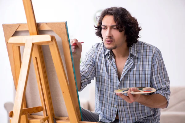 Jovem homem bonito curtindo pintura em casa — Fotografia de Stock