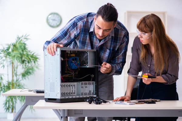 Two repairmen repairing desktop computer