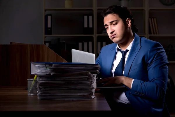 Młody mężczyzna pracownik pracujący w nocy w biurze — Zdjęcie stockowe